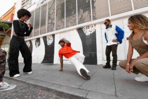 A group of friends enjoying a breakdancing session in an urban setting, highlighting the vibrant community aspect of the History of Hip-Hop.